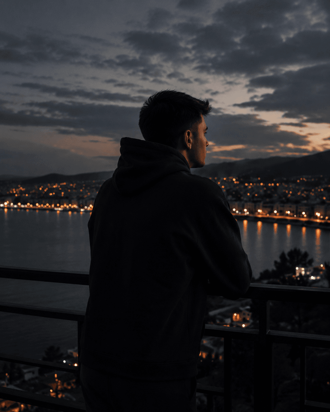 Yusuf Dere overlooking a coastal city at night